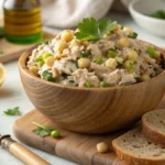 A bowl of vegan tuna salad made with chickpeas and nori, served with whole-grain bread in a cozy kitchen.